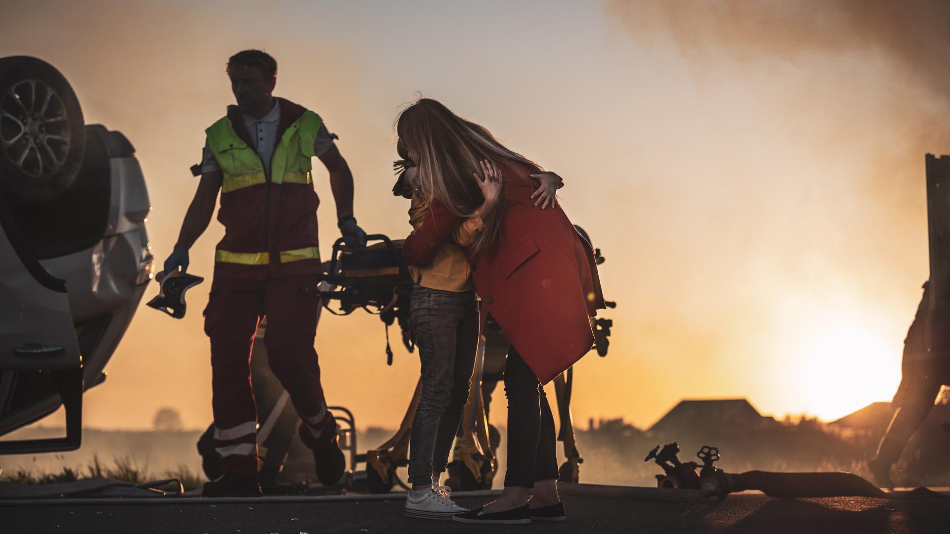 Accidente de tráfico de accidente de coche: La joven herida se reúne con su madre amorosa. En el rollover Car de fondo y los paramédicos y bomberos valientes salvan vidas